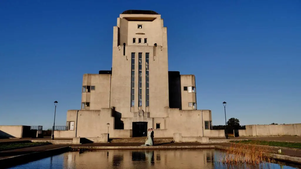 Trouwfilm van Louis en Henrieke op donderdag 24 september 2020. Fotoreportage bij Radio Kootwijk - Bruidspaar voor het gebouw.. Cinematische trouwfilm en Same Day Edit.